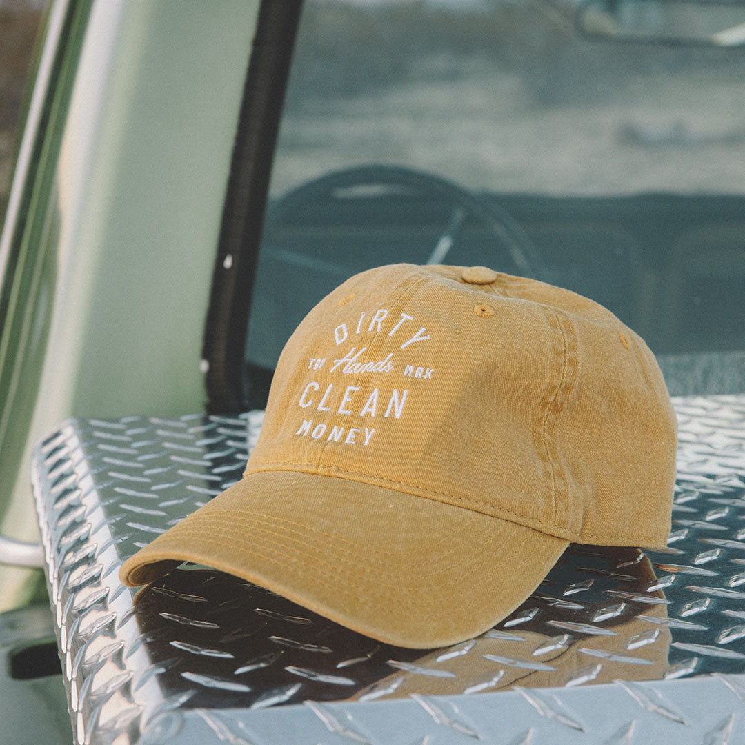 Washed Saddle Juno dad hat with the slogan Dirty Hands Clean Money